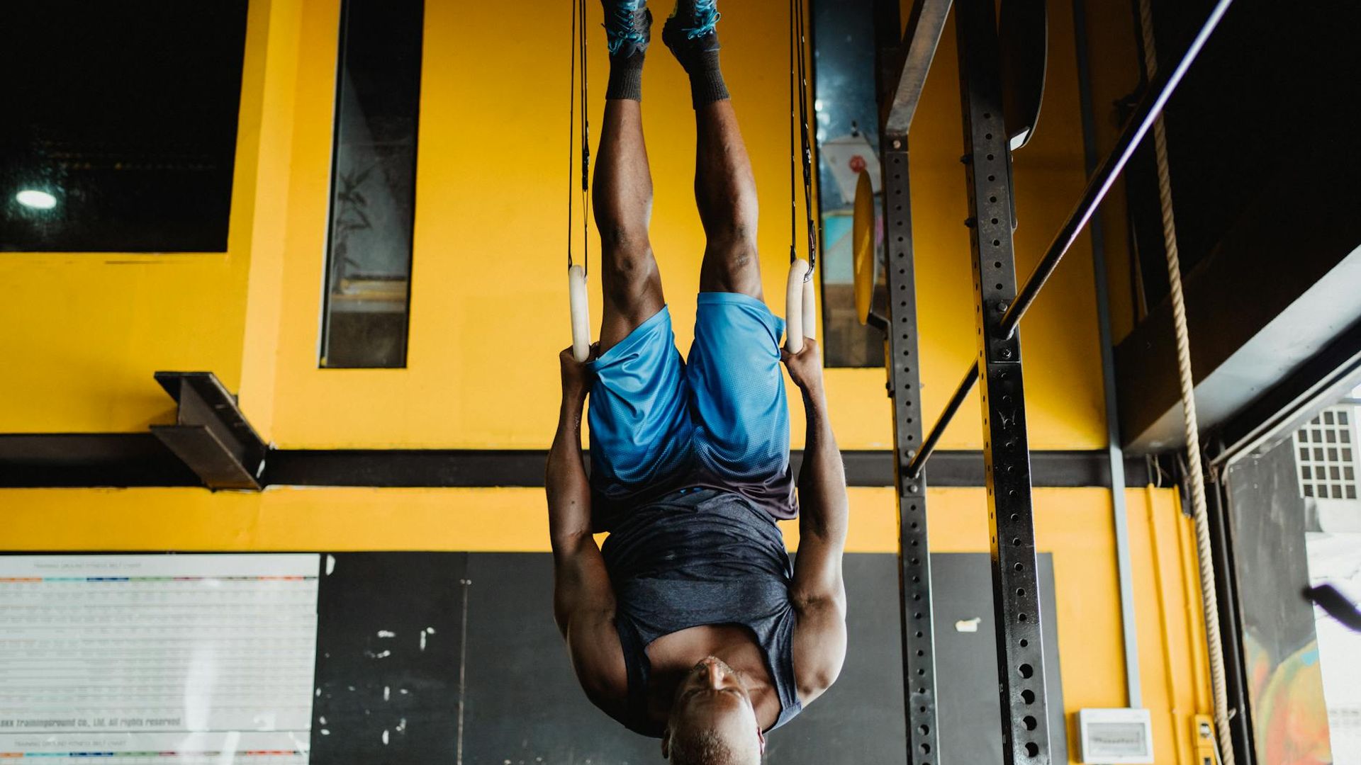 Man performing a controlled bodyweight exercise in a minimalist gym.